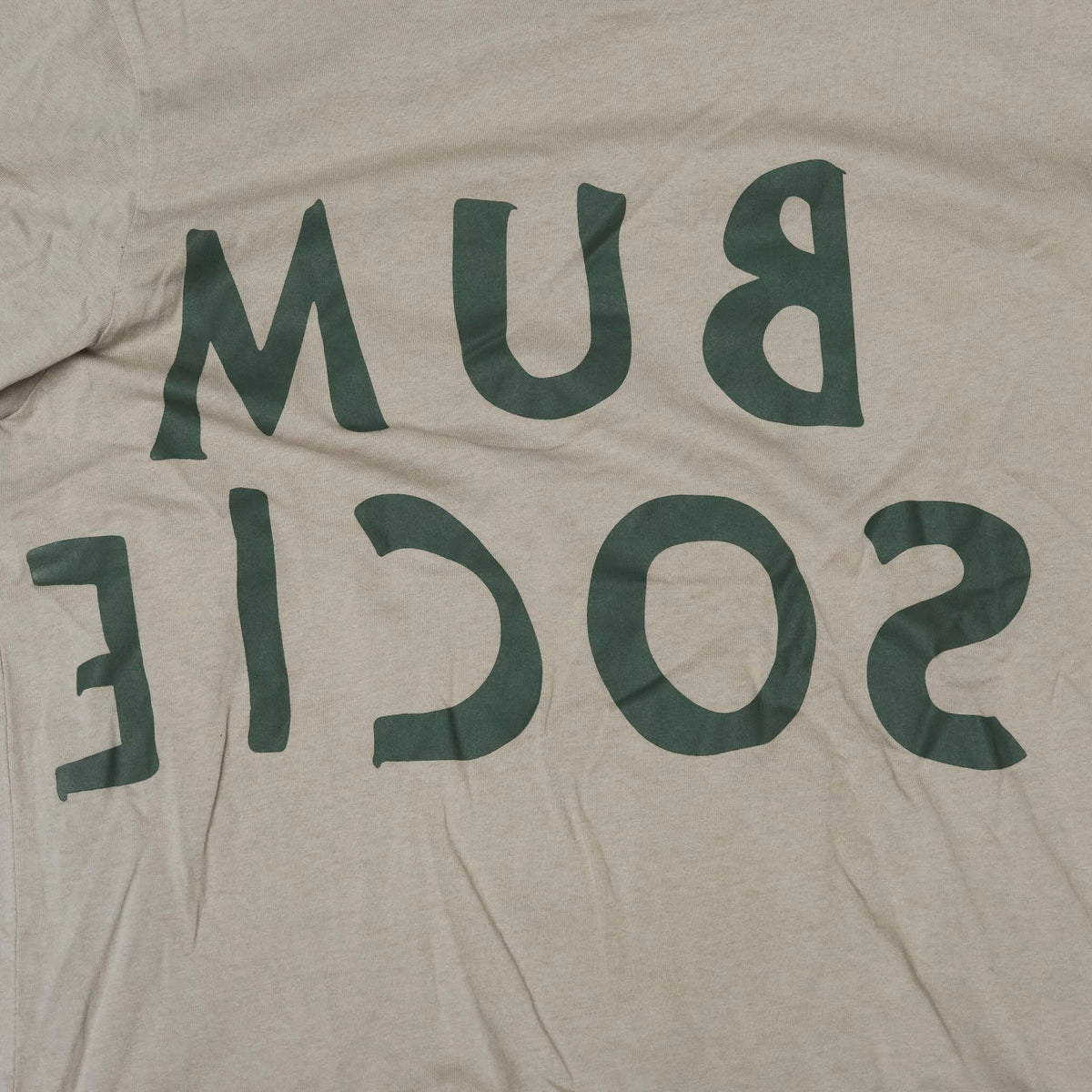 Close up reversed Bum Society logo print color:mud