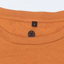 Close-up of a burnt orange garment with Bum Society neck print with four-leaf clover color:bs orange