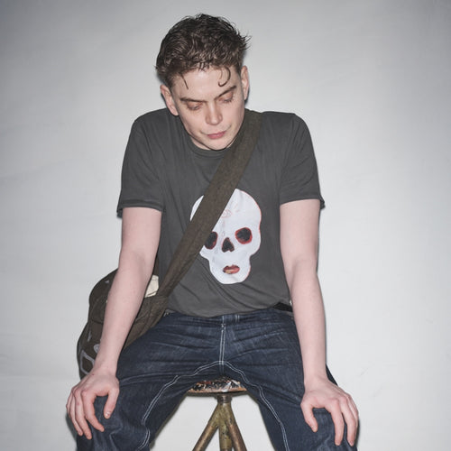 Person sitting on stool in Waldersten x Bum Society t-shirt original artwork Cry Baby color:ink