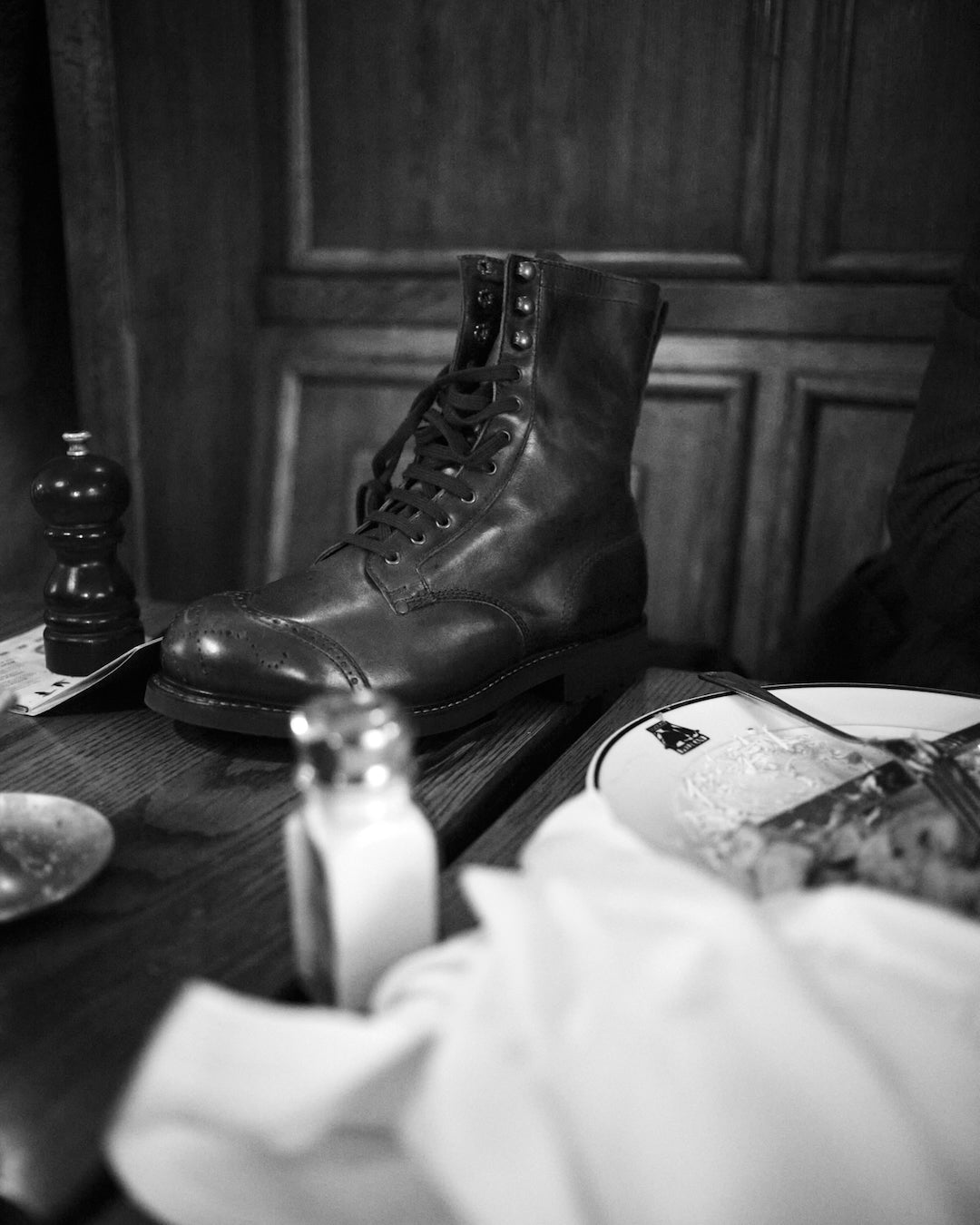 Bum Society brown leather boots on a wooden table with a blurred background