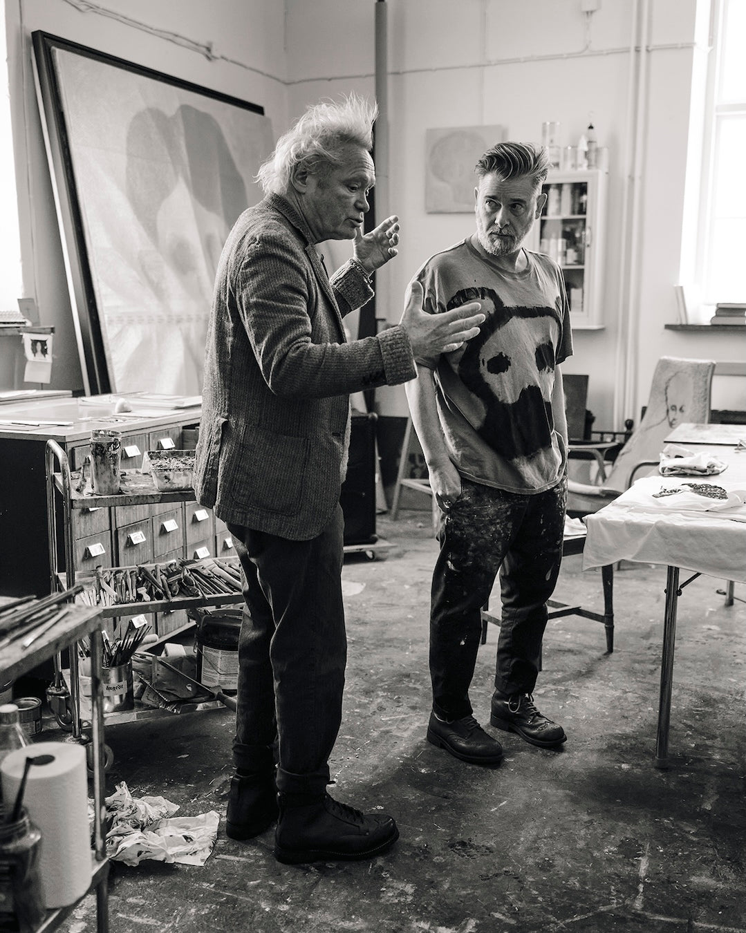 Jesper Waldersten Claes Bondelid in  studio with art supplies and a painting in the background.