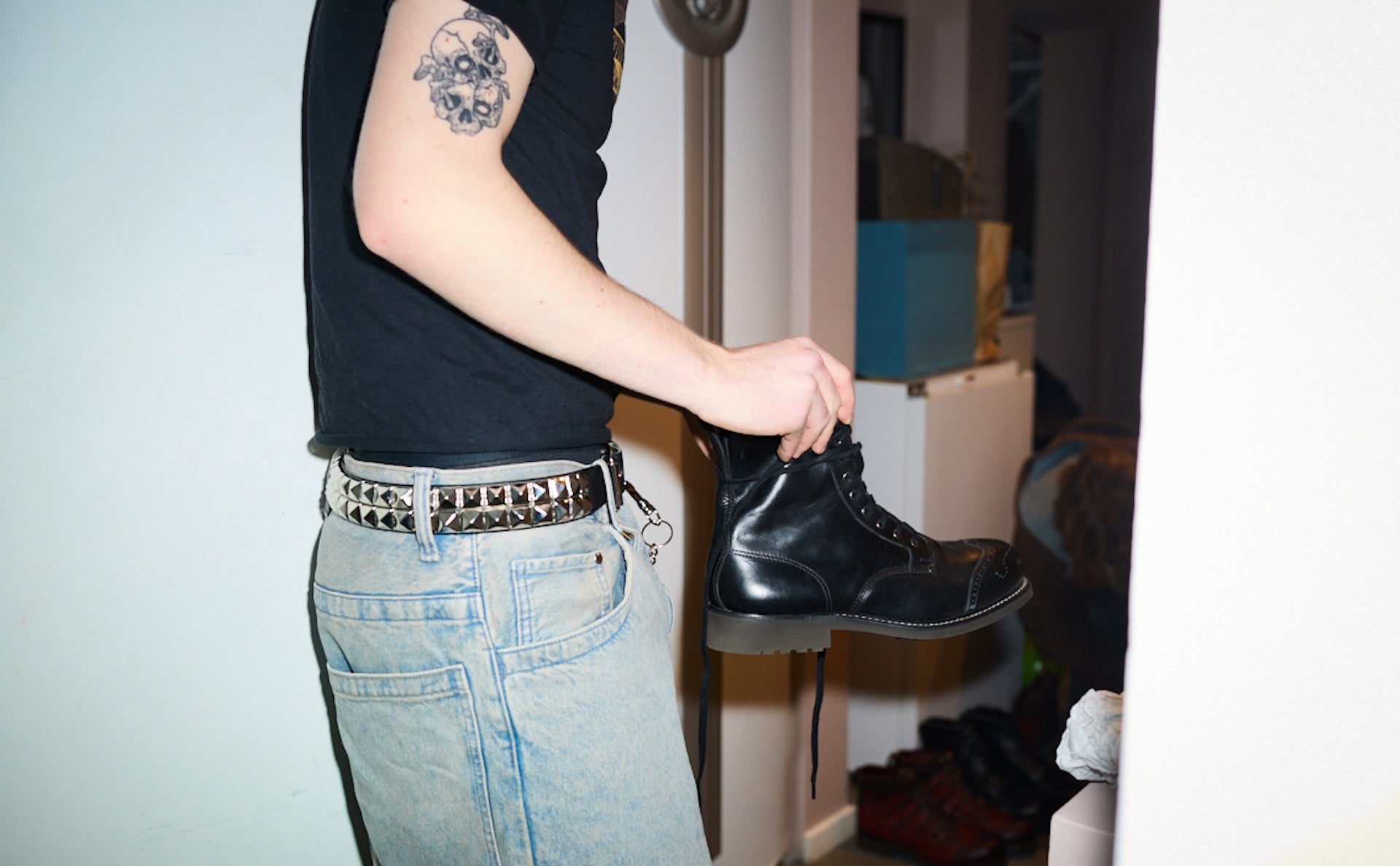 Agaton Gadd  wearing Bum Society black leather boots and blue jeans, standing in hallway