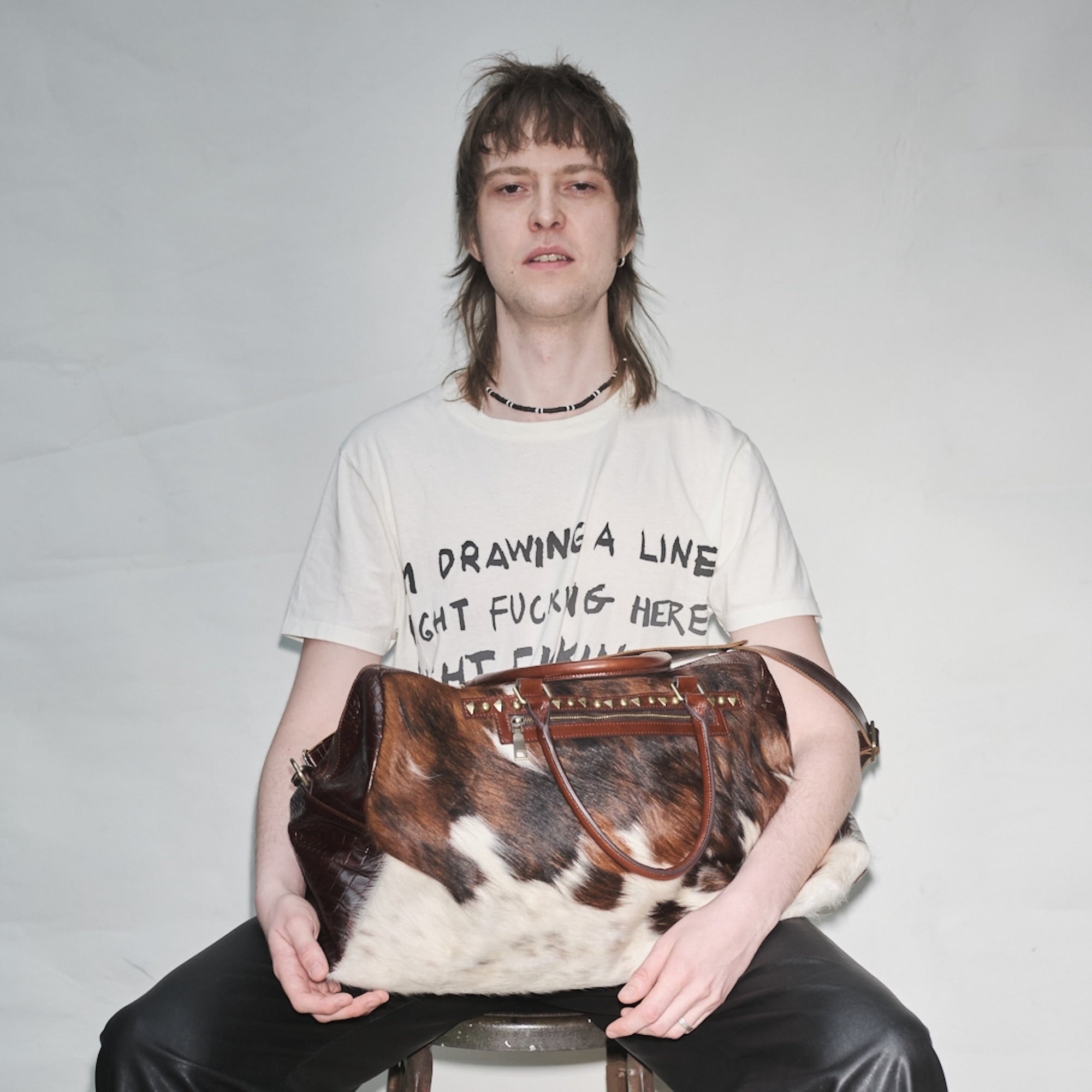 Person holding a pony hair Bum Society duffle bag Dandy Brown against a plain background color:dandy brown, snow