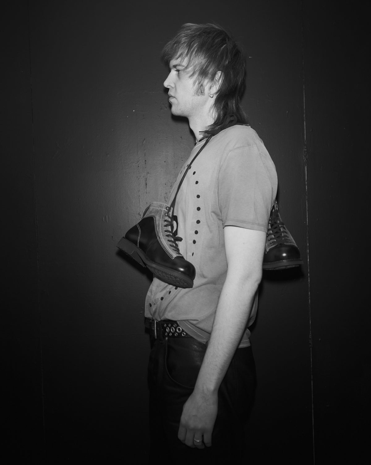 Douglas Diamond holding a Bum Society boots against a dark background