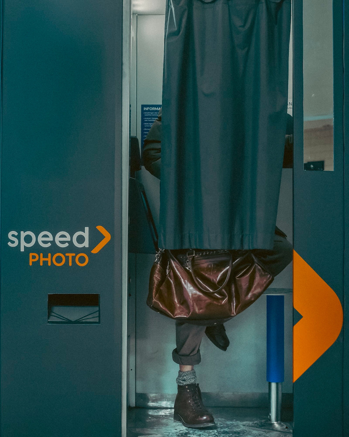 Person standing in a photo booth with 'speed PHOTO' branding.