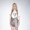 Person wearing a snow colored t-shirt with an original Jesper Waldersten artwork Happy Dead on Bum Society t-shirt and a gray skirt on a plain background color:snow