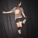 Person wearing a Fuck On, Ongoing t-shirt  t-shirt by Bum Society standing on stool against a black curtain color:ink